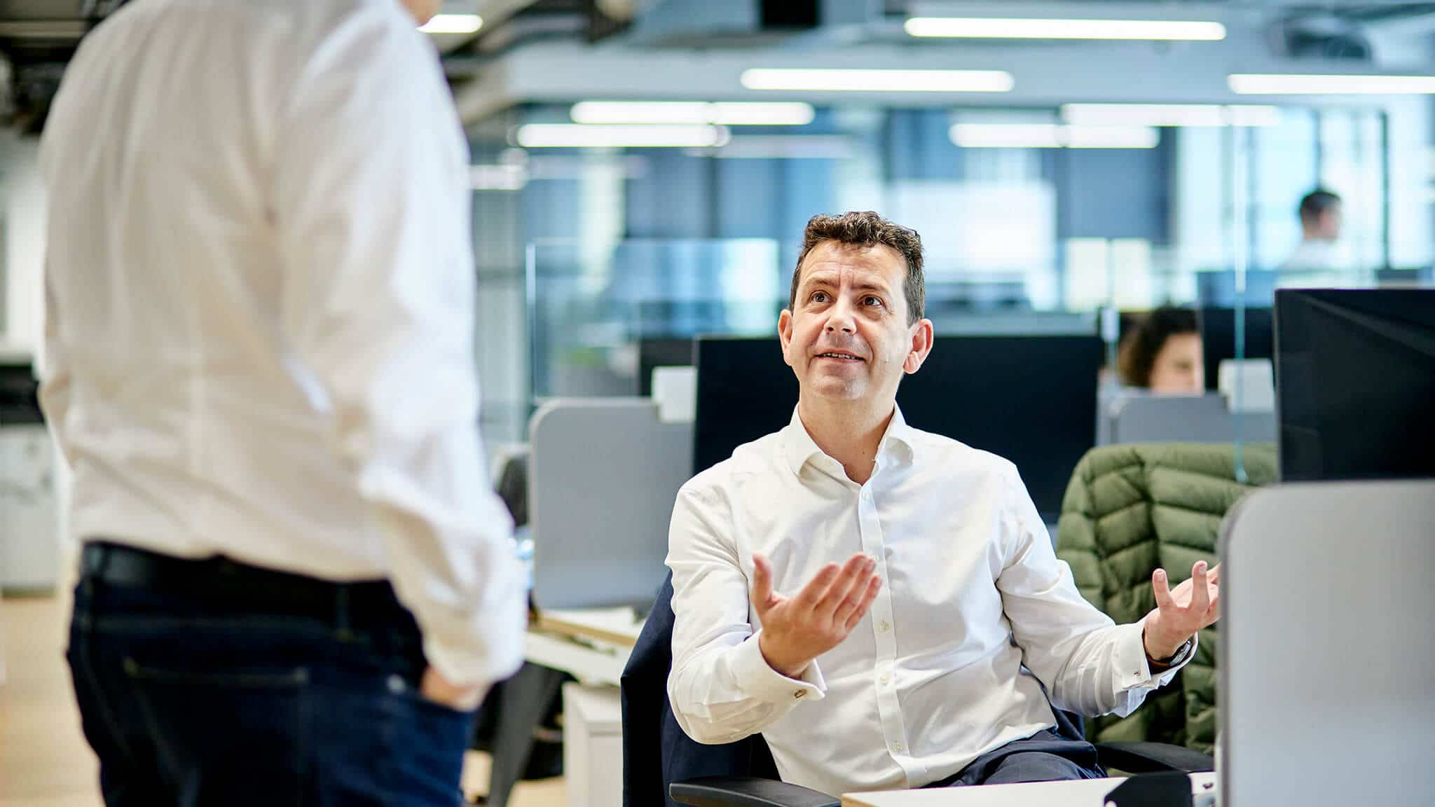 Mat Richards in white shirt gesturing with open palms