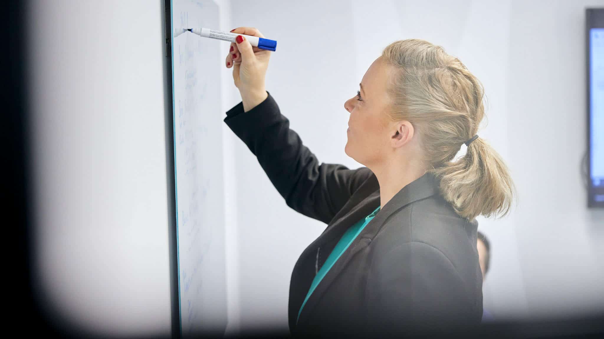 Close up of woman writing on a white board