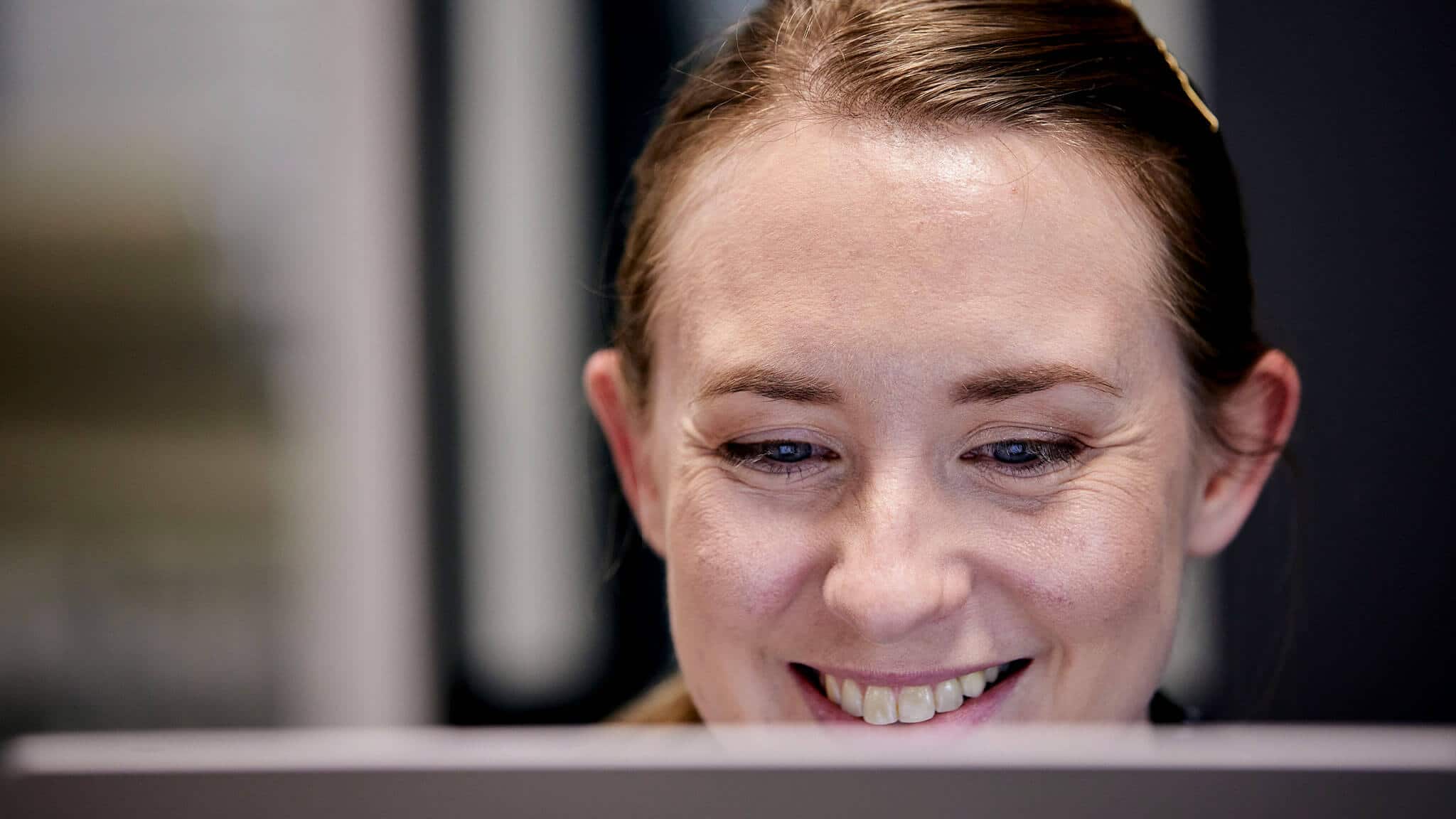 Close up of smiling woman&#039;s face behind screen