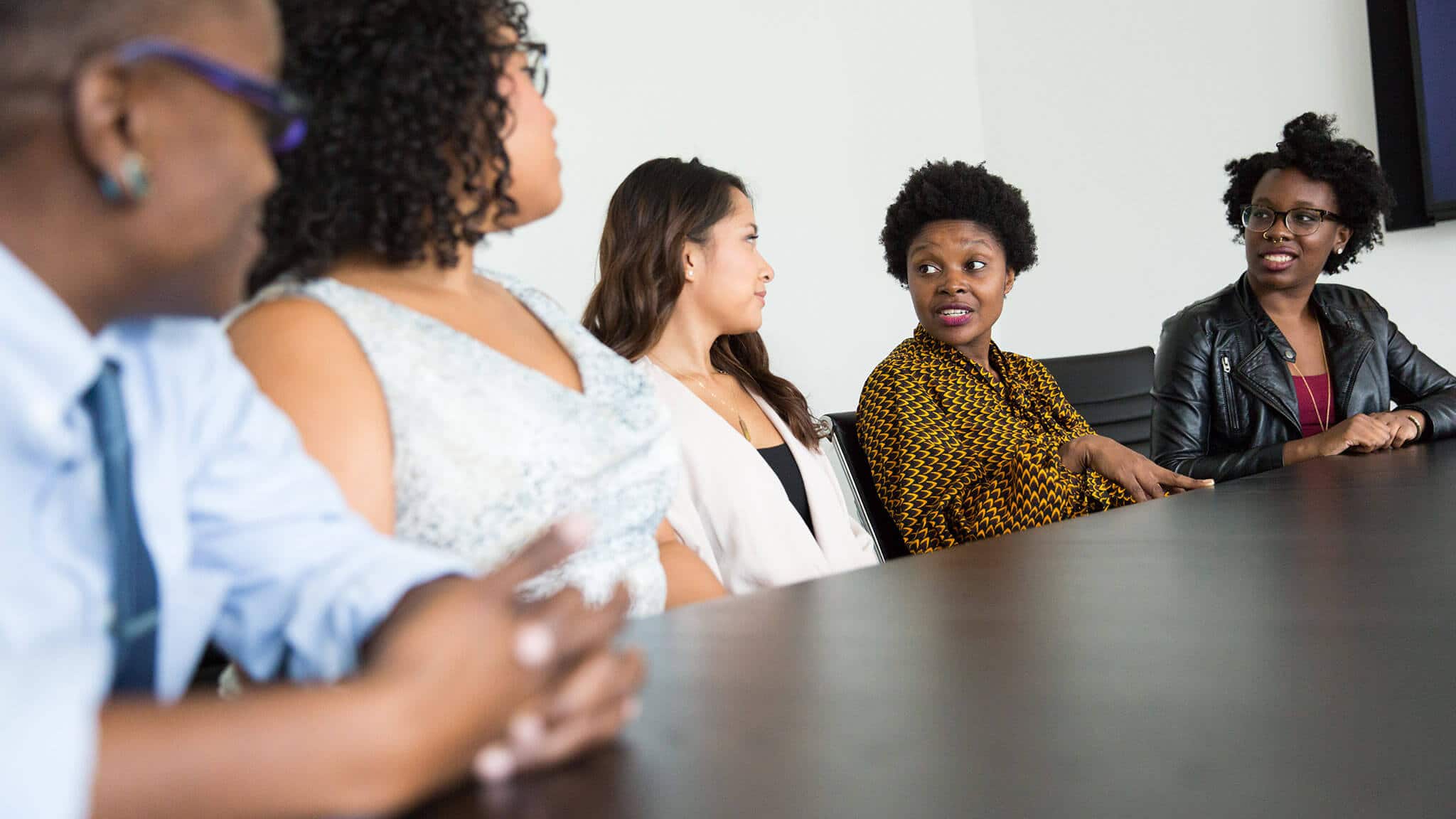 Wide angle shot of women sat at table in discussion