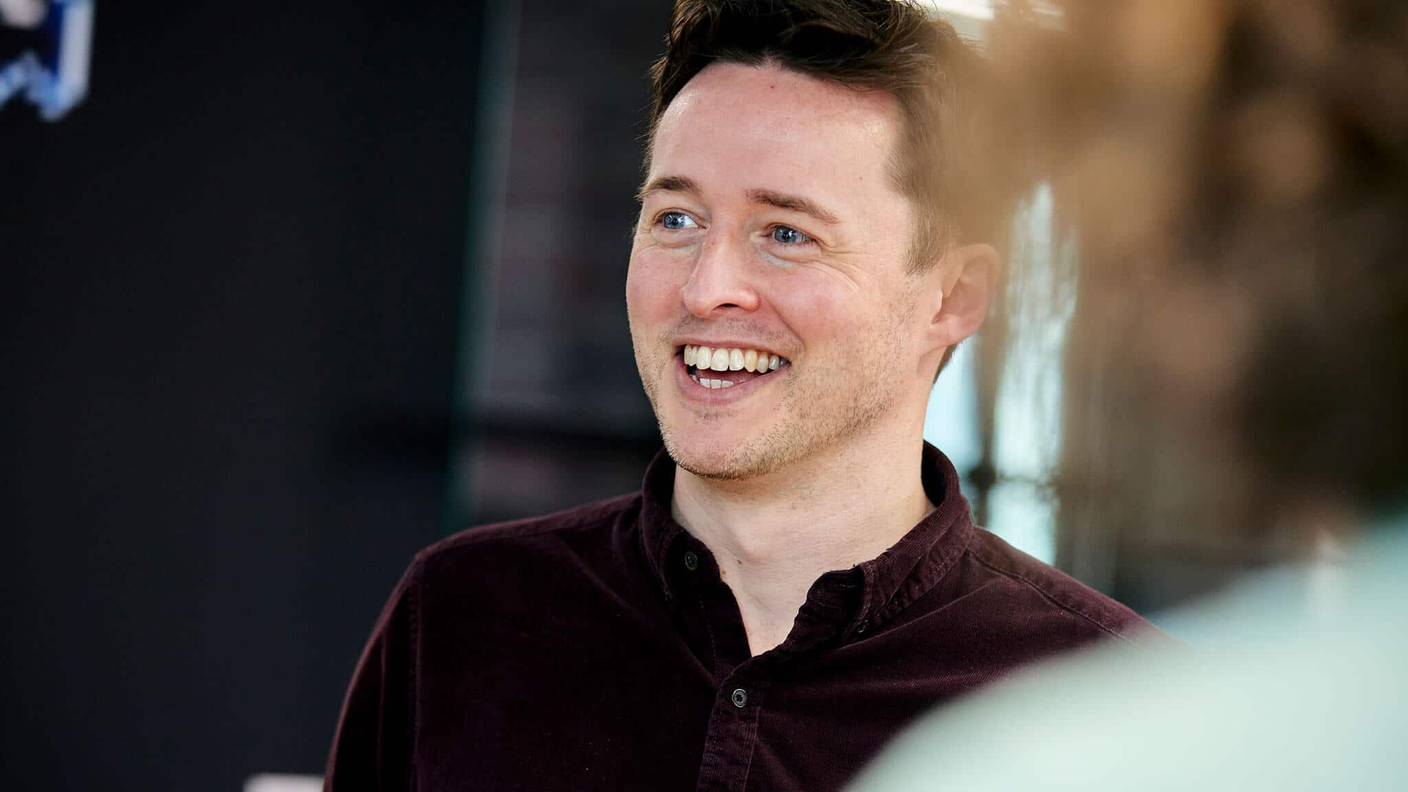 Close up of Lewis Coburn in a maroon shirt smiling