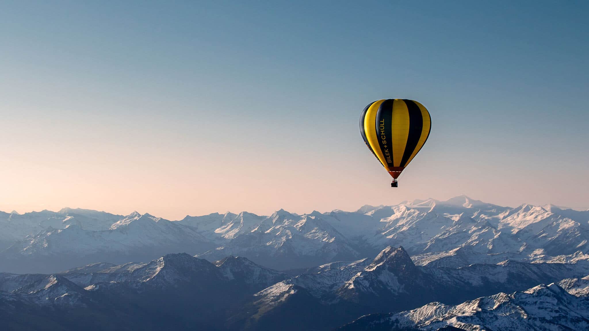 Hot air balloon flying over mountains