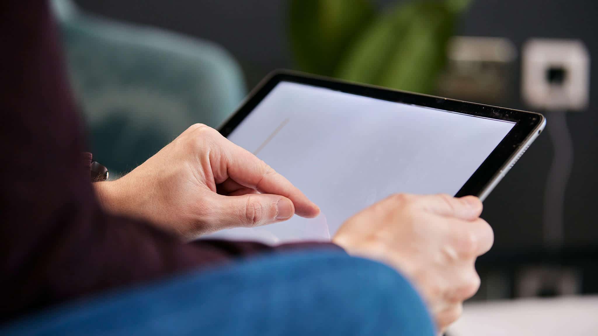 close up of a man&#039;s hands operating a tablet