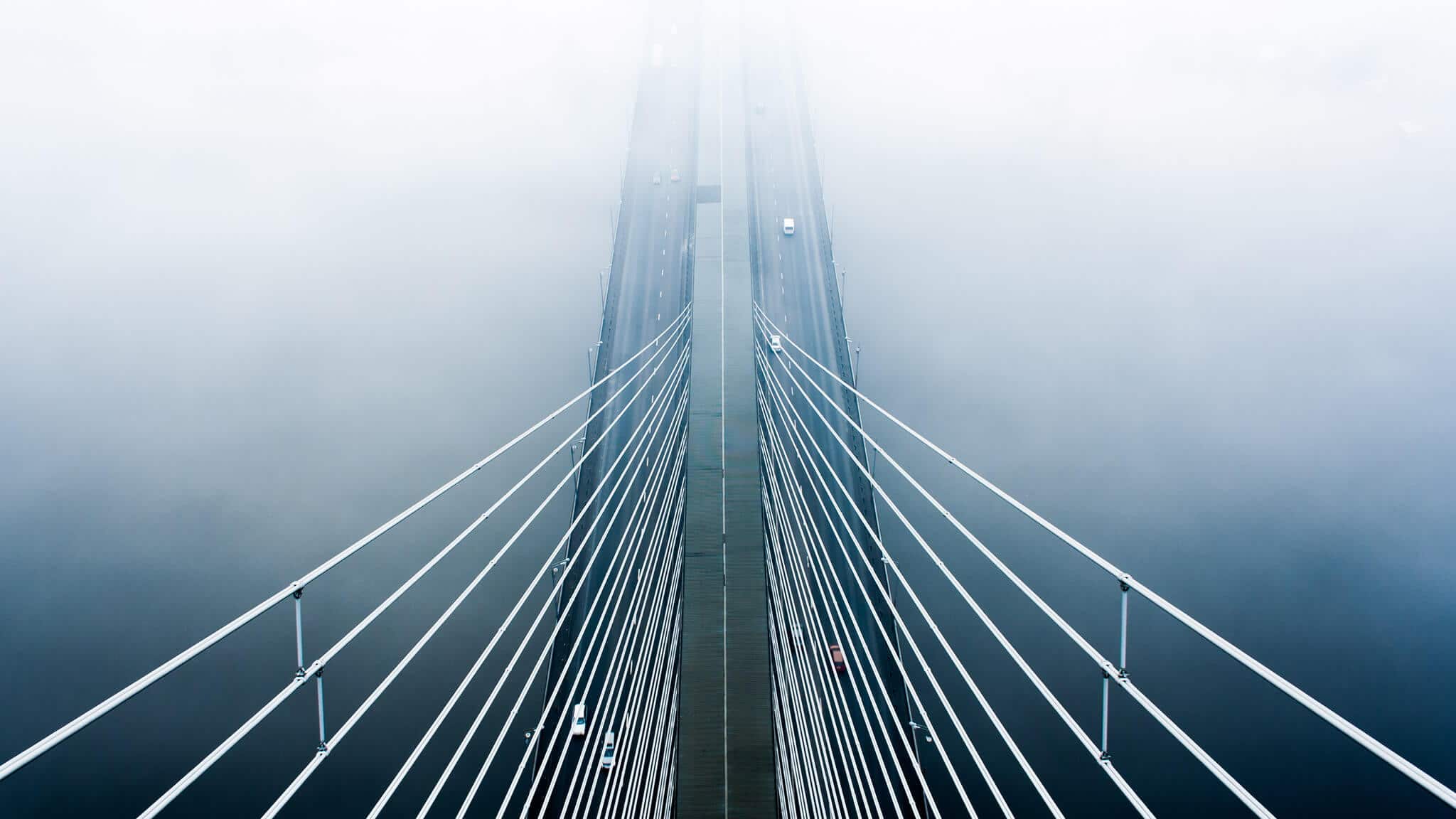 Aerial shot of cantilever bridge with cars on it in mist