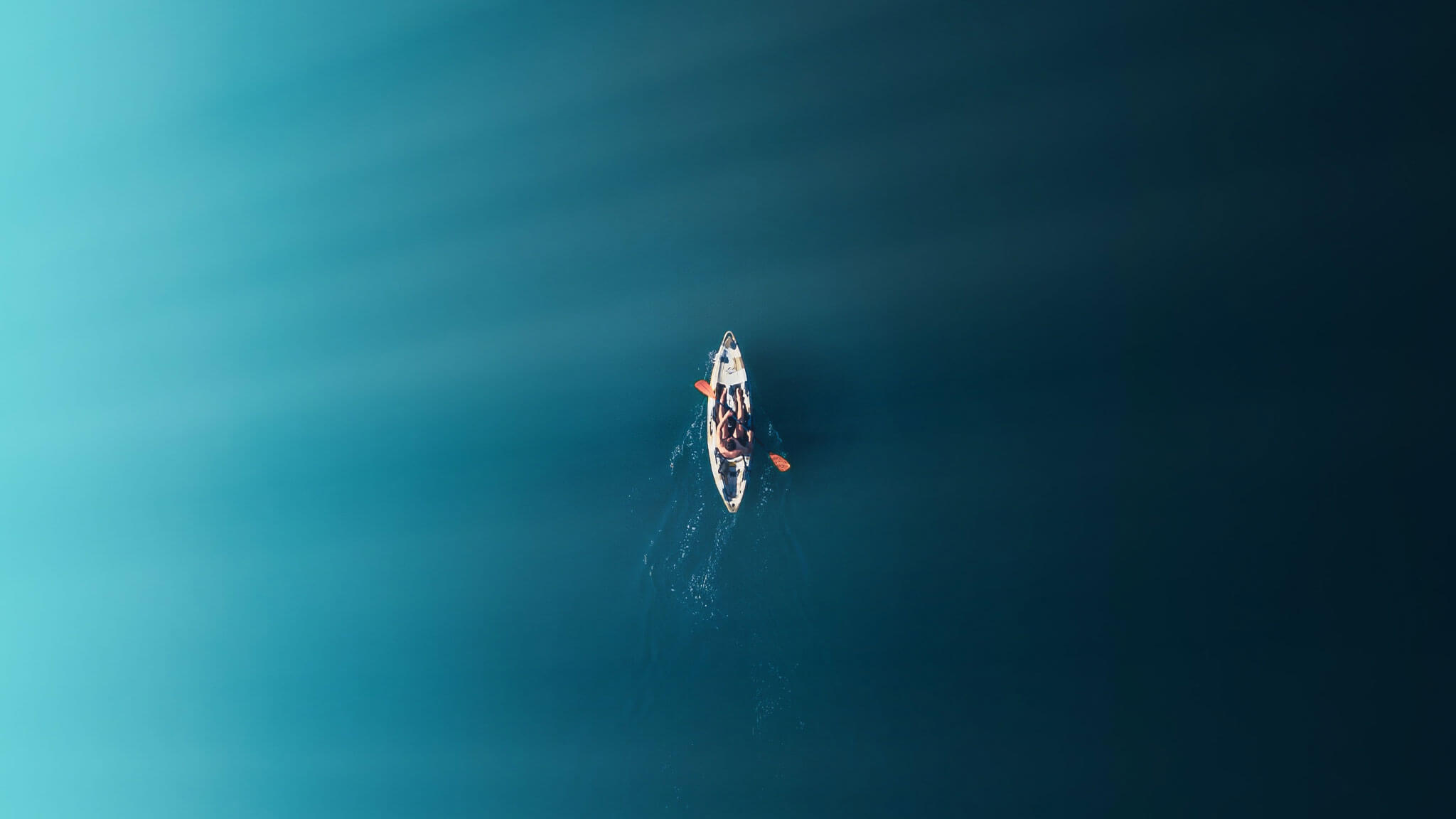 Aerial shot of person in canoe on still water
