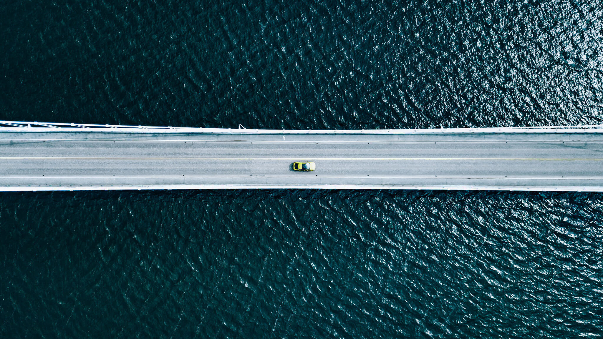 Overhead view of yellow car on a bridge