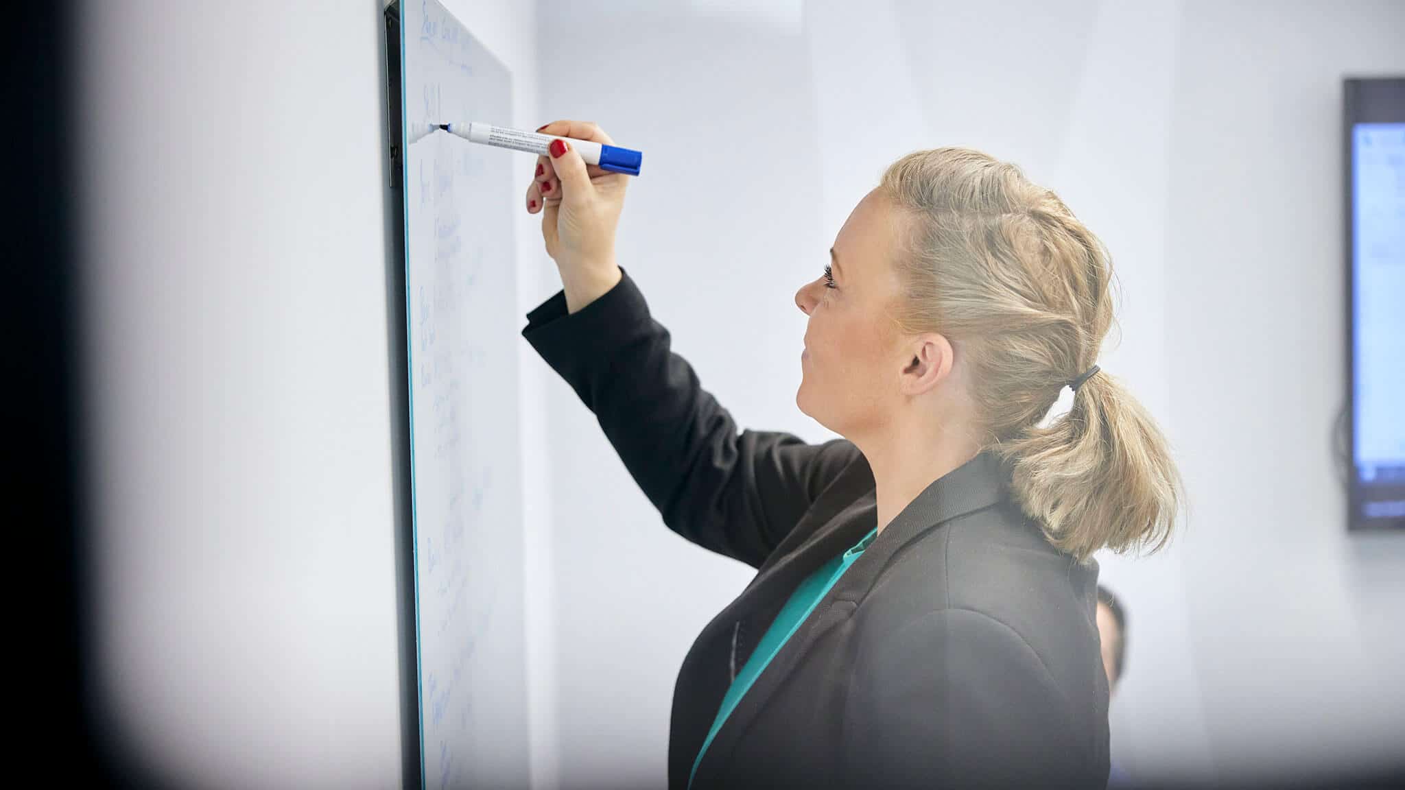 Close up of woman writing on a white board