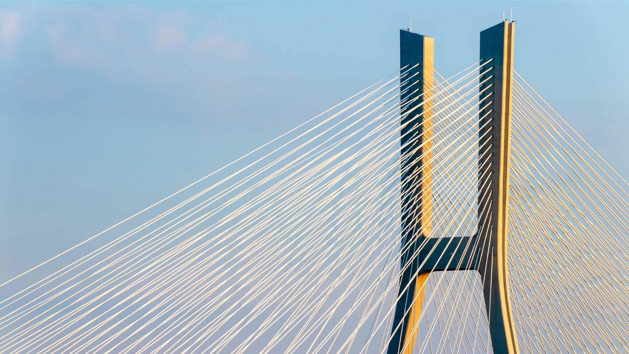 Wide angle shot of cables on a cantilever bridge in the sun.