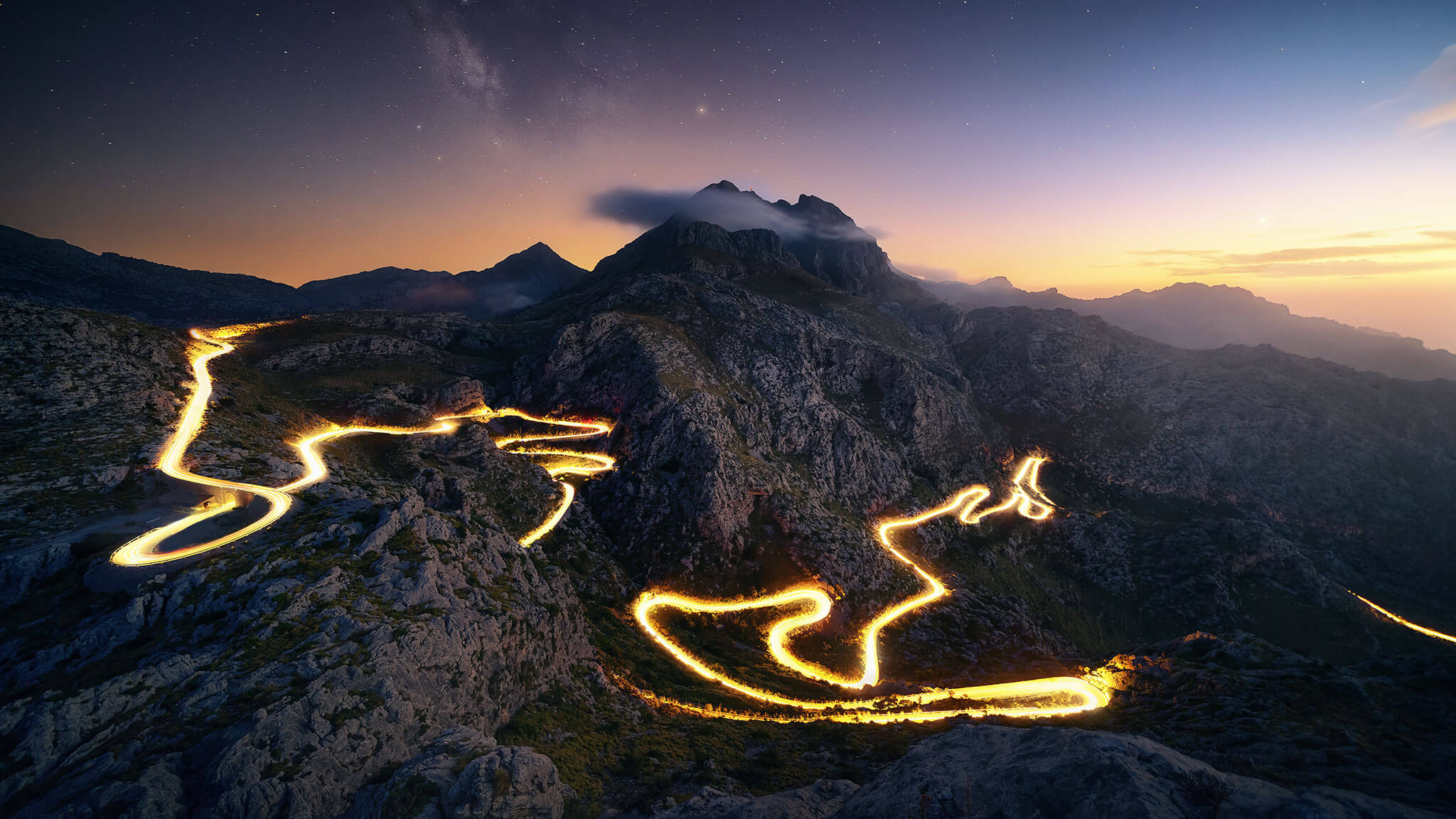 Mountain peaks at night with lava trails