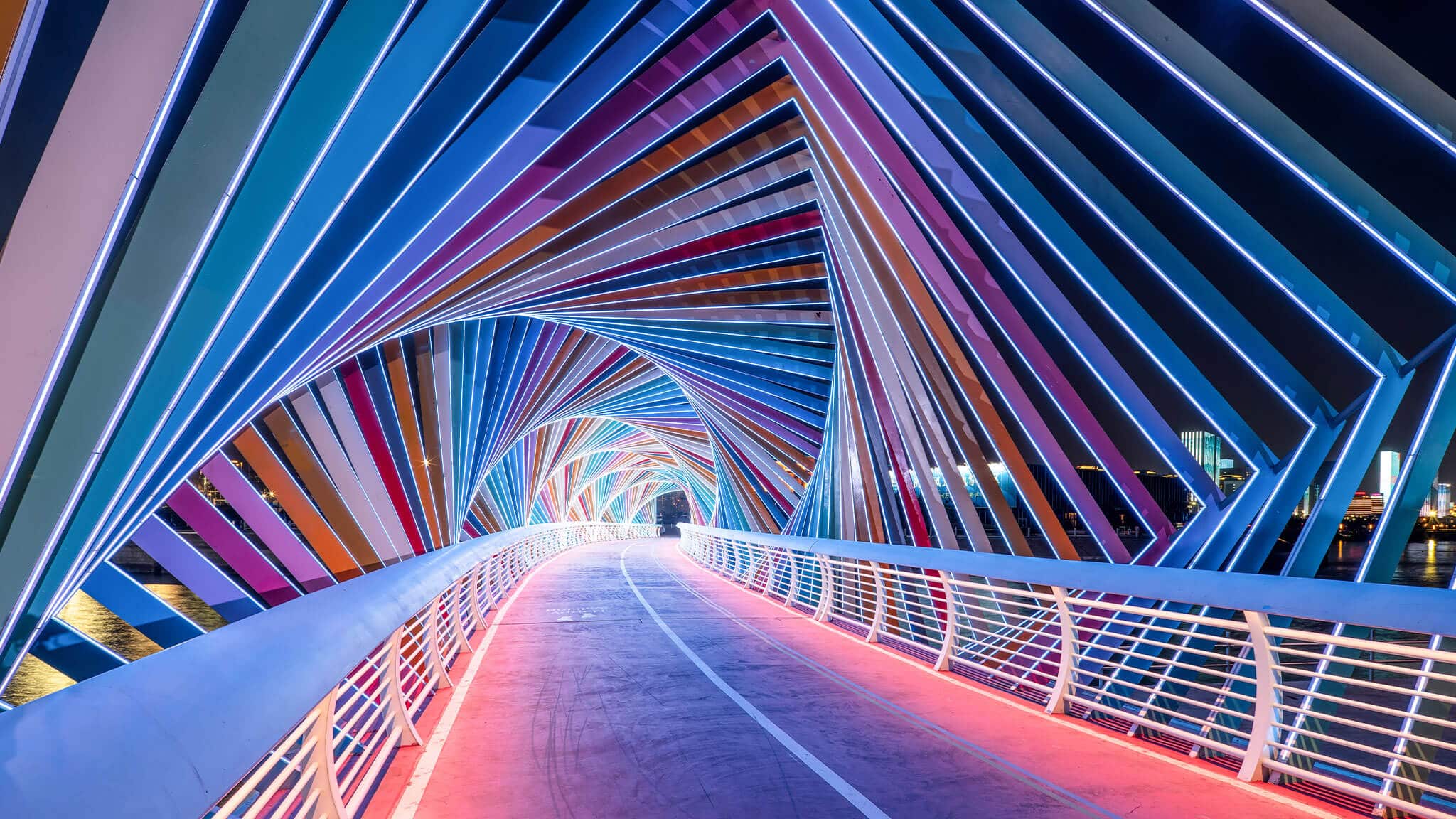 Wide angle shot of geometric bridge shape lit in multicoloured light
