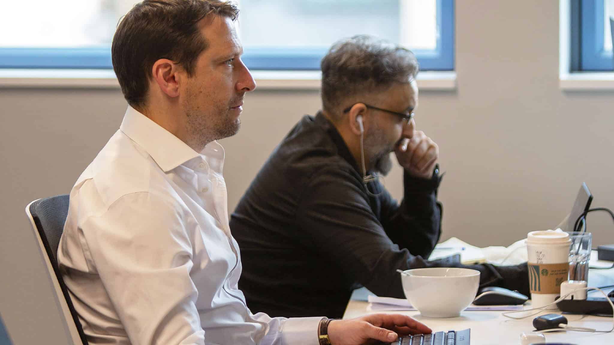 Office workers sat at their desk looking at computer screens.